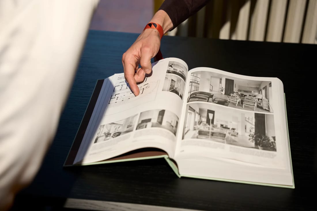 Un ospite sfoglia un volume di architettura negli interni della villa