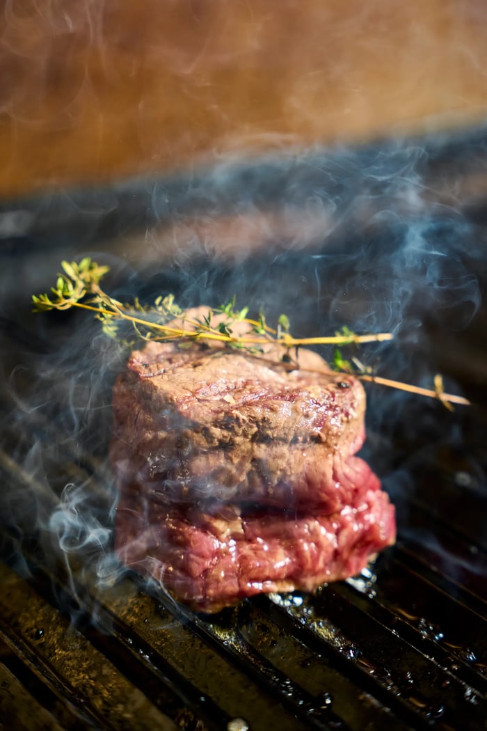 Filetto di manzo fumante sulla brace con rametto di timo — cottura alla griglia, fotografo carne gourmet Alchimia Milano