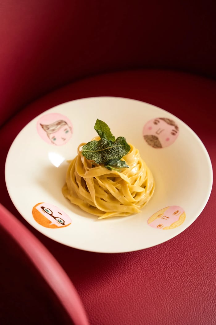 Tagliatelle al burro e salvia su piatto artistico con ritratti illustrati — pasta all'uovo artigianale, fotografo food FATA Milano