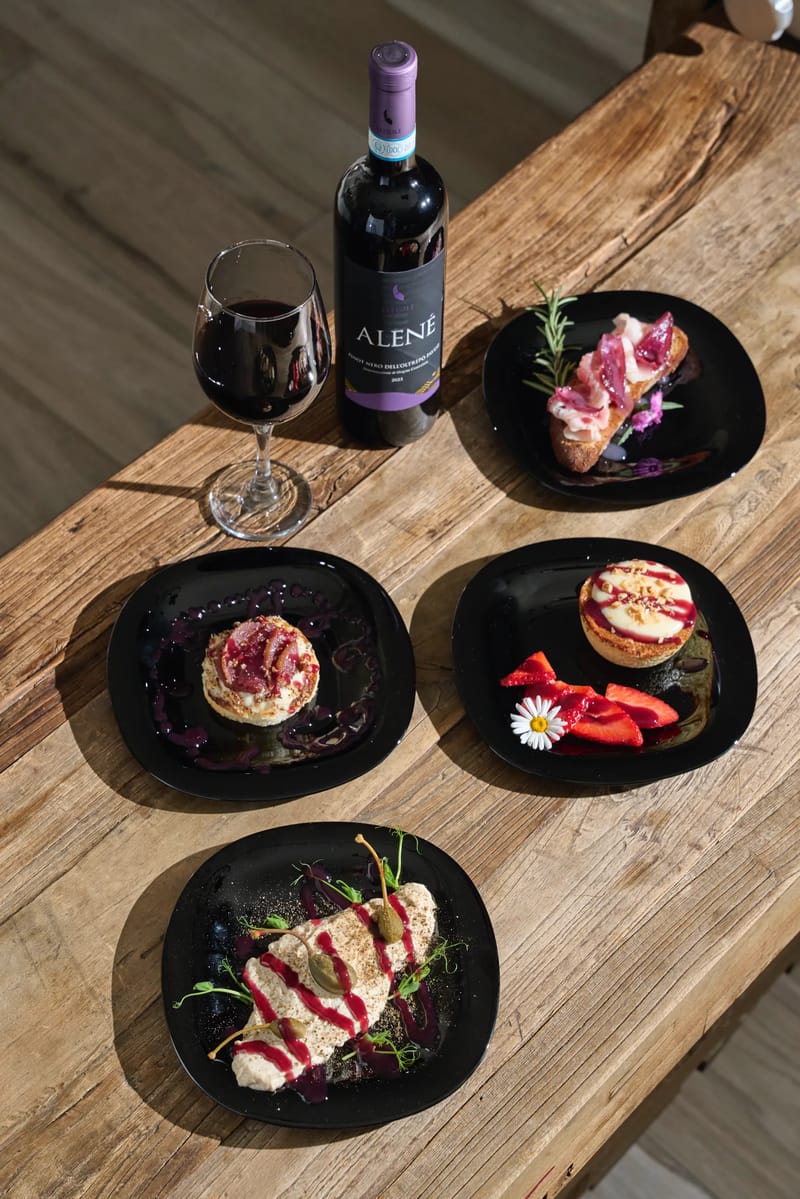 Selezione di antipasti su piatti neri con bruschetta e tartelletta