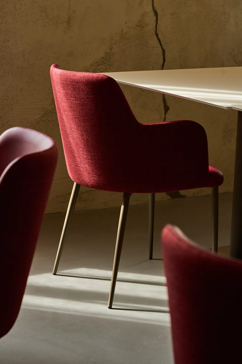 Poltrona di velluto bordeaux e tavolo in marmo nella sala del ristorante